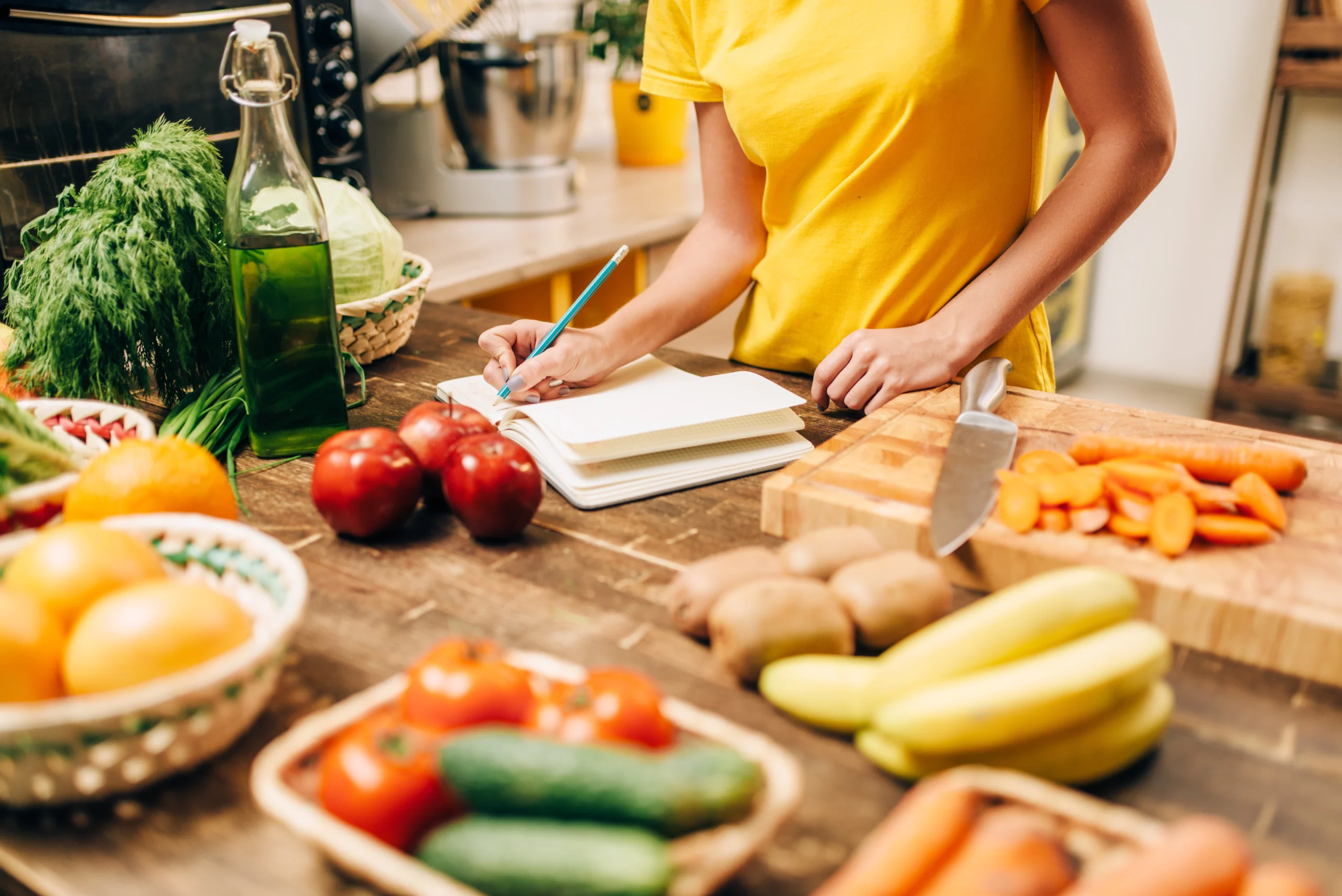 image of a person tracking food consumption with food around her, as a part of a personal fitness plan.