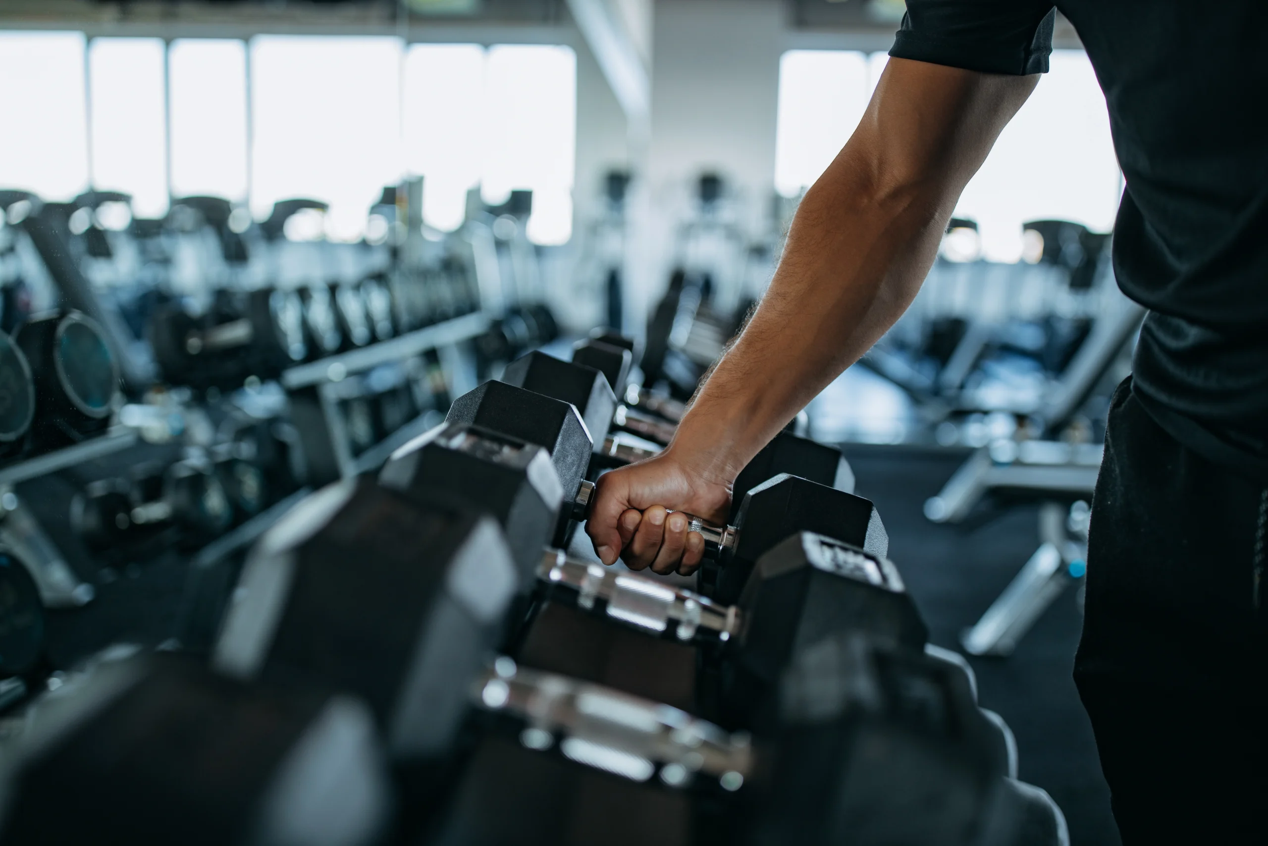 photo of man's arm grabbing a dumbbell before personal training session.